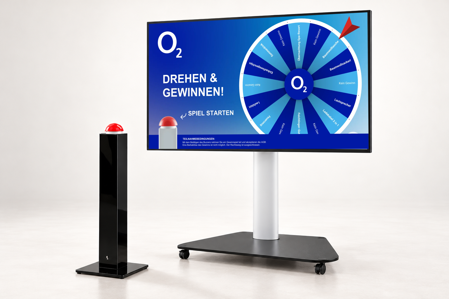 GAMIFY Glücksrad Setup: Bildschirm auf fahrbarem Standfuß mit o2 Glücksrad und daneben eine Buzzer-Stele mit rotem Buzzer